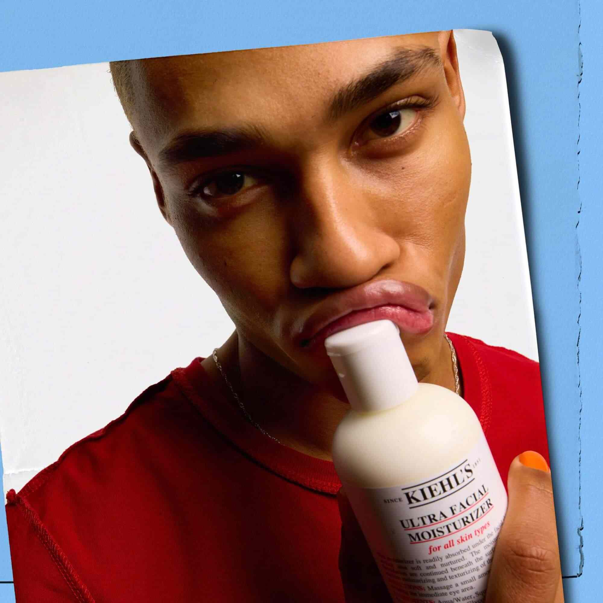 Modelka pritlačajuca fľaštičku Kiehl's Ultra Facial Moisturizer k peram