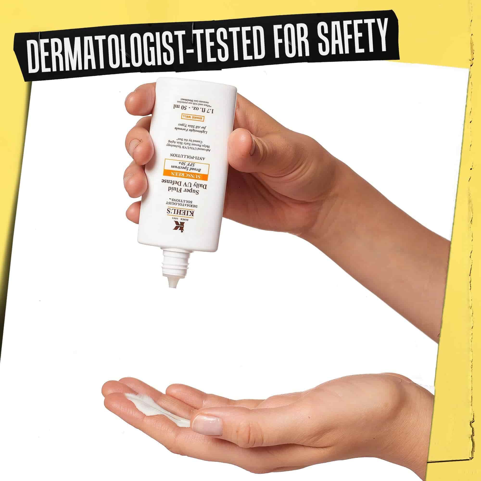 Ruka, na ktoru sa davkuje Ultra-Light Daily UV Defense, s napisom „Dermatologicky testovane pre bezpečnosť“.