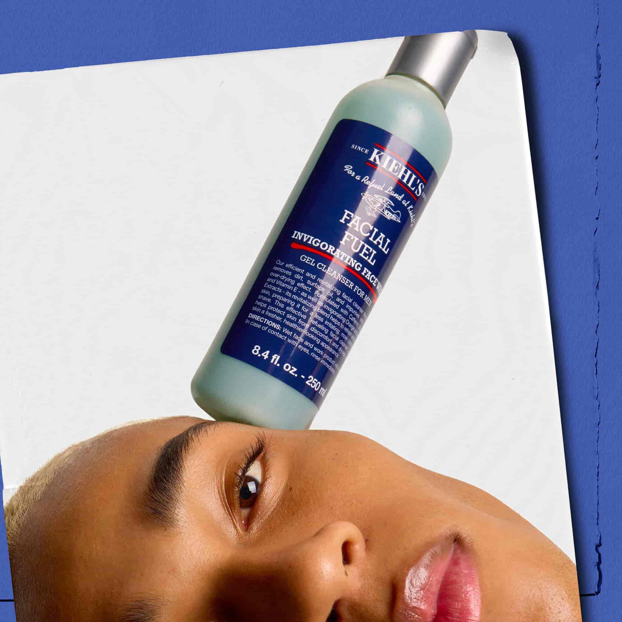 Model s fľaštičkou energizujuceho čistiaceho gelu Kiehl's Facial Fuel balansujucou na tvari