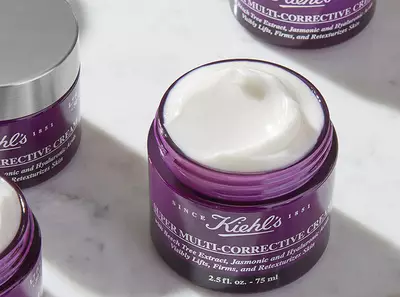 Fialovy krem na tvar Kiehl's s extraktom z jazminu a hyaluronovou kyselinou v otvorenej fľaštičke.