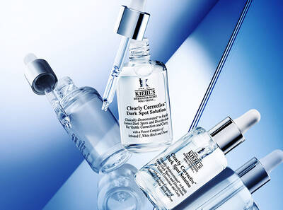 Seria ser Kiehl's, vratane Clearly Corrective Dark Spot Solution, na zvyraznenom modrom pozadi.
