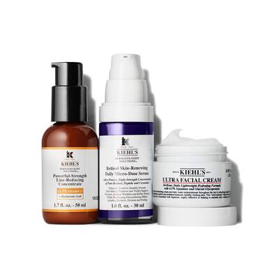 Three skincare products from Kiehl's displayed: a brown bottle labeled "Powerful-Strength Line-Reducing Concentrate," a blue bottle labeled "Retinol Skin-Renewing Daily Micro-Dose Serum," and a white jar labeled "Ultra Facial Cream."